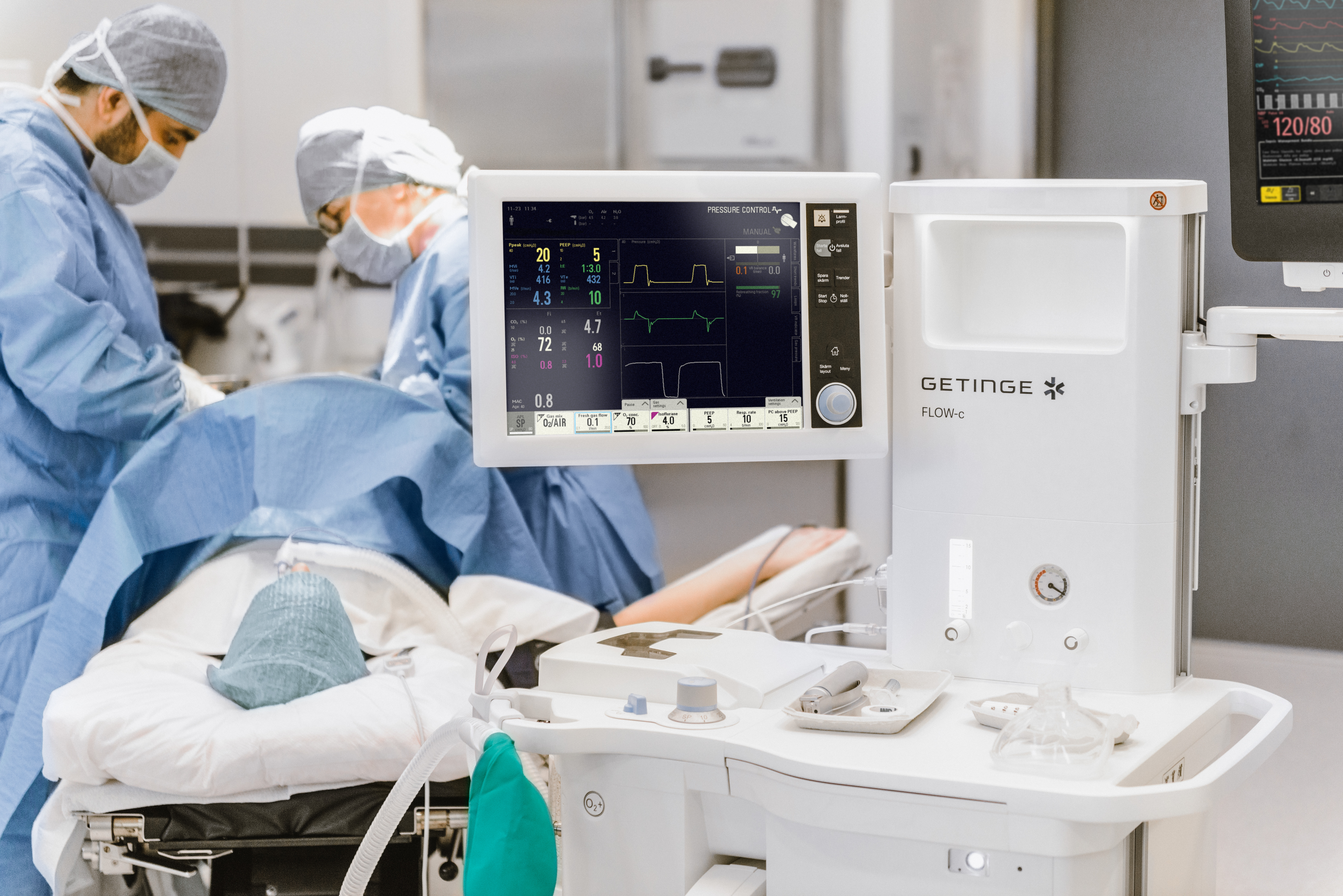 Surgery in progress with medical staff and monitoring equipment in a hospital operating room.