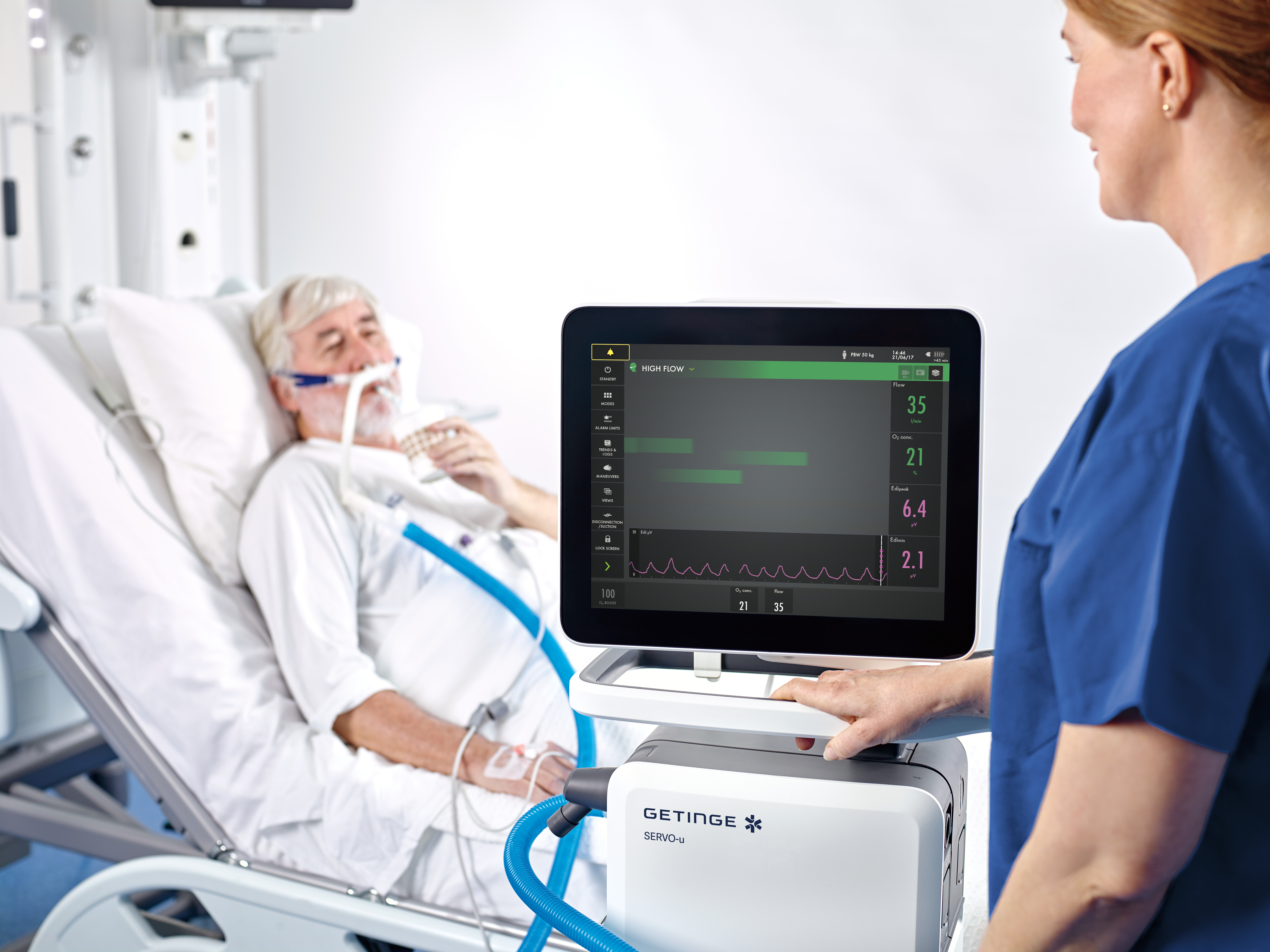 Patient in a hospital bed using an oxygen mask, with a nurse checking a monitor displaying vital signs.