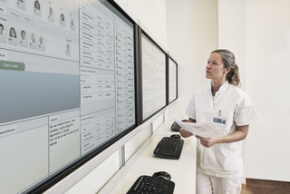 Medical staff stand in front of bog monotor overviewing the INSIGHT interface 