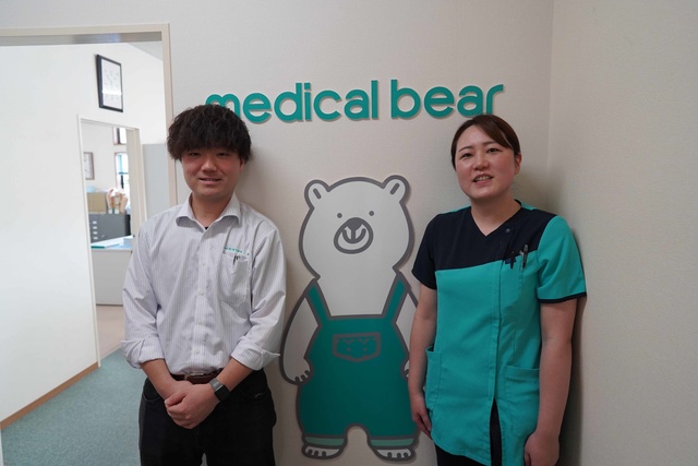 Customer service manager and CSSD manager from Medical Bear standing in front the company logo 