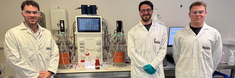 Drie mannen poseren voor de ww5 bioreactoren en Livit Flex op de locatie van ENOUGH