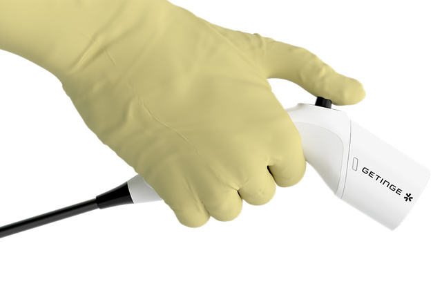 Fluobeam fluorescence imaging probe held with a medical glove, connected by cable, used for intraoperative visualization.