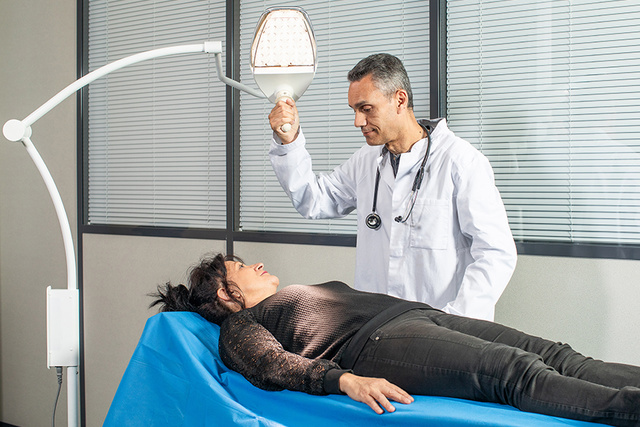 doctor illuminating a patient with an examination lamp