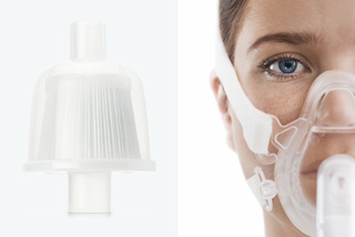 Breathing device components next to a person wearing a mask.