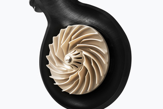 A black turbine housing showcasing a metallic, spiral turbine wheel against a white background.
