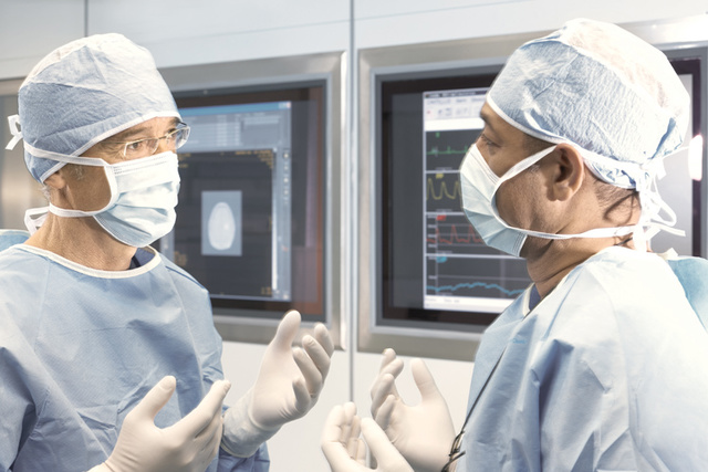 doctors with gloves speaking in front of a screen
