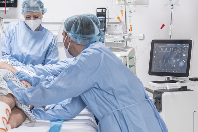 ww5 Servo-u mechanical ventilator in clinical environment showing patient being rolled into prone position by clinicians 